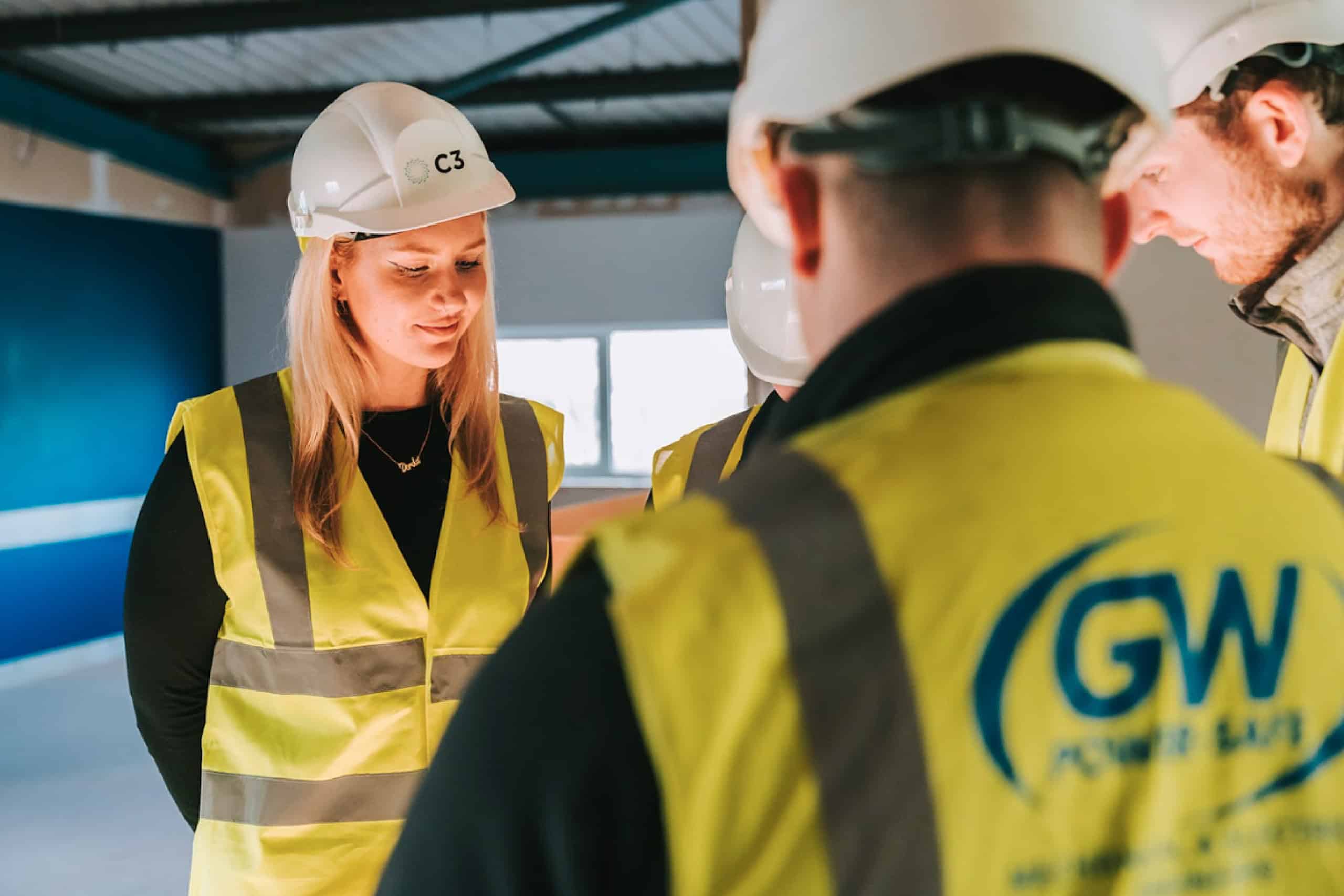 Members of C3 Group and GW Power in high vis vests and hard hats, discussing on site